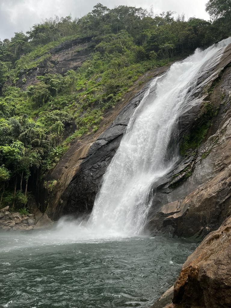 A powerful waterfall cascading through misty hills in the Sohra region