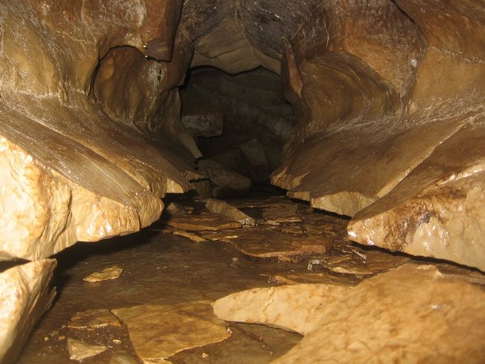 A person standing in the vast chamber of Liat Prah Cave, showcasing its immense size