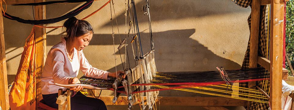 A local artisan weaving a traditional handloom shawl