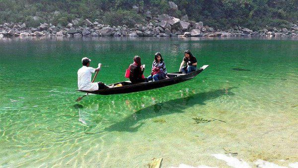 Crystal-clear Umngot River with a boat appearing to float in the air