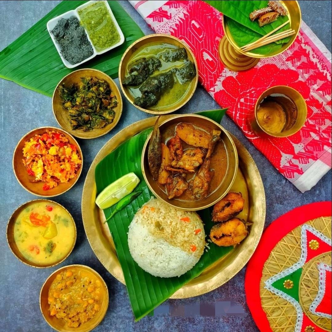 A traditional Assamese thali meal with rice, lentils, and side dishes