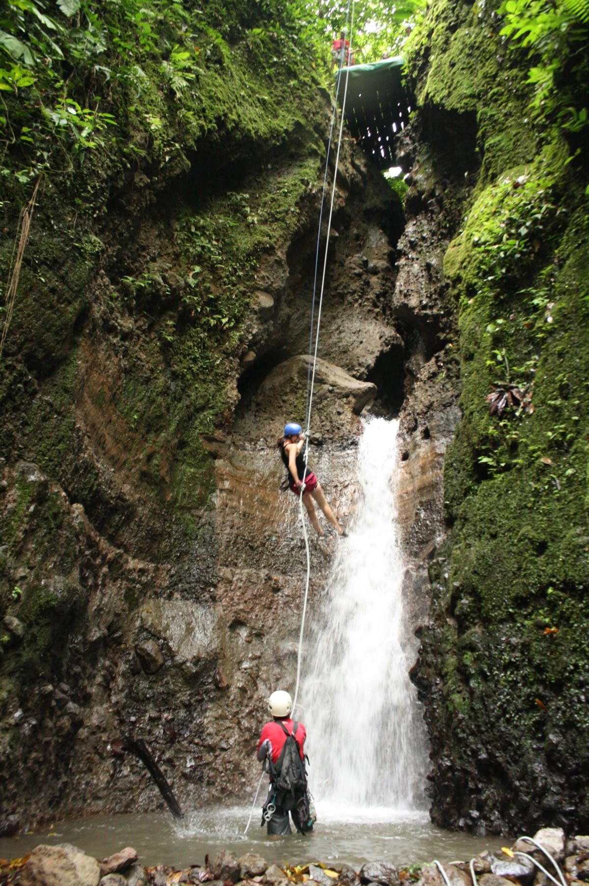 A lit-up tent by a river, with stars in the night sky